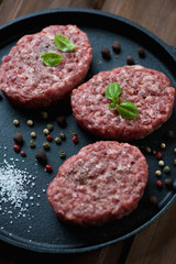 Frying pan with raw cutlets made of minced beef meat, close-up