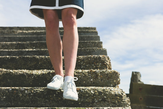 The legs of a woman walking down stairs