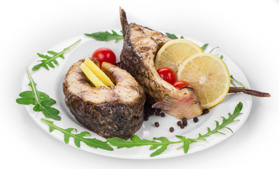 Grilled carp steaks with lemon and tomatoes.