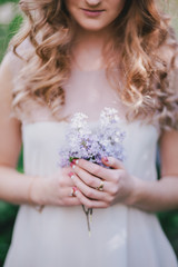 Young woman with long beautiful hair posing with lilac