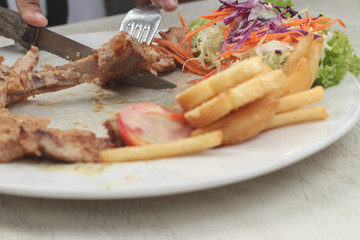 steaks and vegetable salad with french fries.