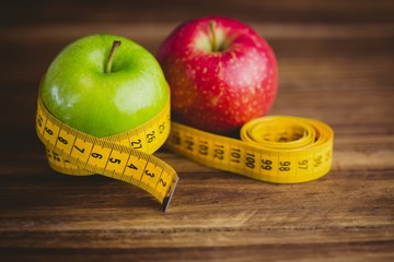 Green and red apples with measuring tape