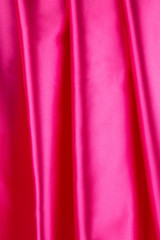 Soft folds of pink silk cloth texture.