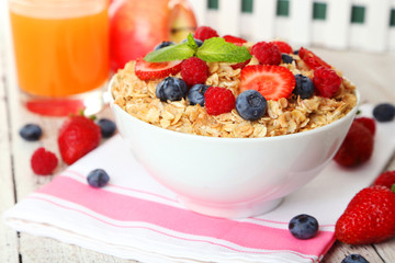 Oatmeal with berries on white wooden background