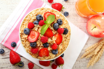 Oatmeal with berries on white wooden background