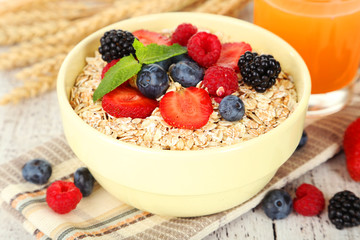 Oatmeal with berries on white wooden background