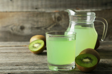 Fresh juice with kiwi on grey wooden background