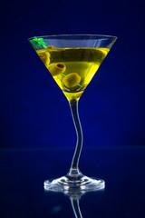 Martini drink served on glass table with ice cubes