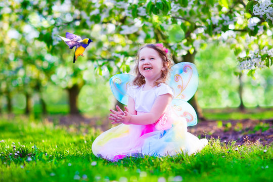 Little Girl In Fairy Costume Feeding A Bird