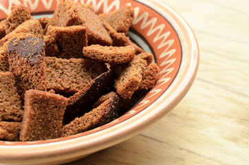 Rye bread rusks in a bowl on a wooden background