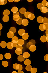 Golden lights, blurred to gold discs, against a black background