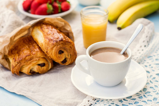 Cup of coffee with french croissant with chocolate