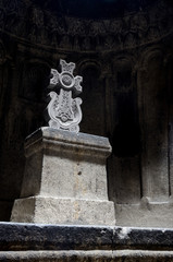 Fototapeta na wymiar Hall of ancient christian rock temple Geghard with a cross