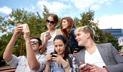 students or teenagers with smartphones at campus