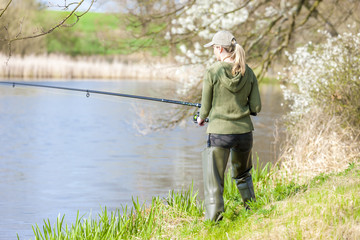 woman fishing at pond in spring