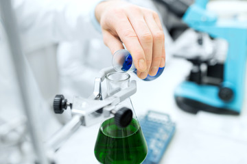 close up of scientist filling test tubes in lab