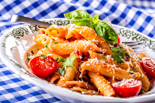 Plate with pasta pene cherry tomatoes basil leaves  