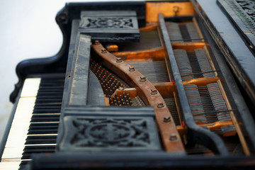 Old piano detail with keyboard, wooden carved ornament and mecha