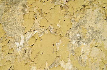 Yellow peeling paint on wall closeup