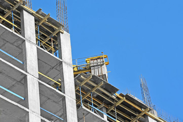 Crane and building construction site against blue sky