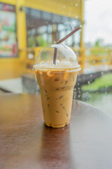 Iced coffee with straw in plastic cup.
