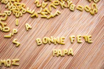 Bonne Fête Papa, écrit avec des petites pâtes, fond bois
