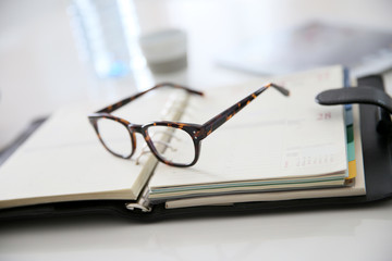 Closeup of eyeglasses set on business agenda