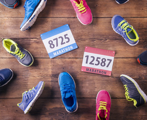Running shoes and numbers laid on a wooden floor background