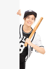 Woman in baseball jersey posing behind a panel