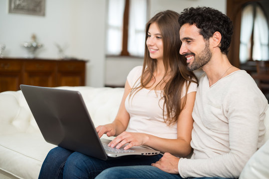 Happy couple using a laptop computer