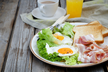 Breakfast on a plate: fried eggs, bacon and lettuce