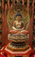 small statue of Buddha, in a Buddhist temple in Singapore