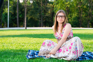 Beautiful young woman with glasses in the park on the grass