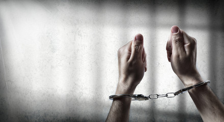 arrest  - man handcuffed in cell prison
