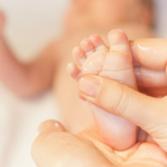 Mother makes massage for newborn baby