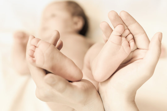 Mother holding baby feet, concept of family and love