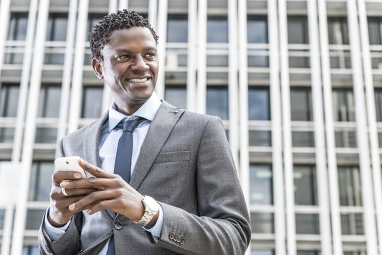 Handsome black businessman with smart phone