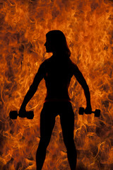 silhouette of fit woman with two weights from back