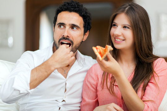 Couple Eating Pizza And Watching TV