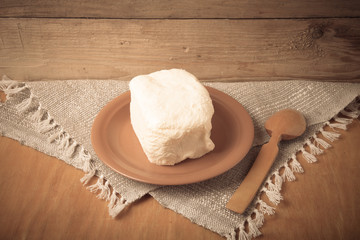 Large piece of butter with spoon on plate on linen napkin. Rusti