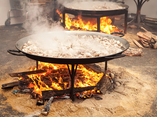 Valencian paella cooking on log fire in local Spainish village