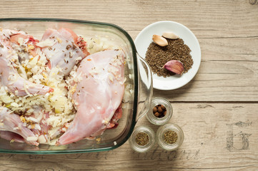 raw rabbit meat in roaster with onion cumin and garlic