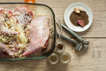raw rabbit meat in roaster with onion cumin and garlic