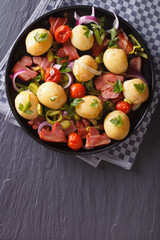 Potatoes with fried bacon and tomatoes top view vertical
