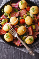 Fried bacon with potatoes on plate closeup. vertical top view
