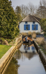 Obraz premium House with thatched roof and a boat in Giethoorn
