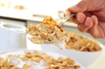young man eating oatmeal cereals with yogurt