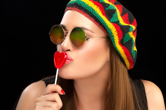 Stylish Young Woman Kissing a Heart Shaped Lollipop
