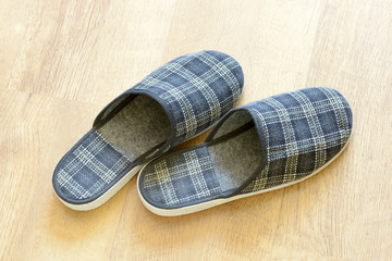 A pair of warm slippers on the wooden parquet
