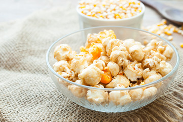 A bowl of popcorn on a wooden table, caramel popcorn
